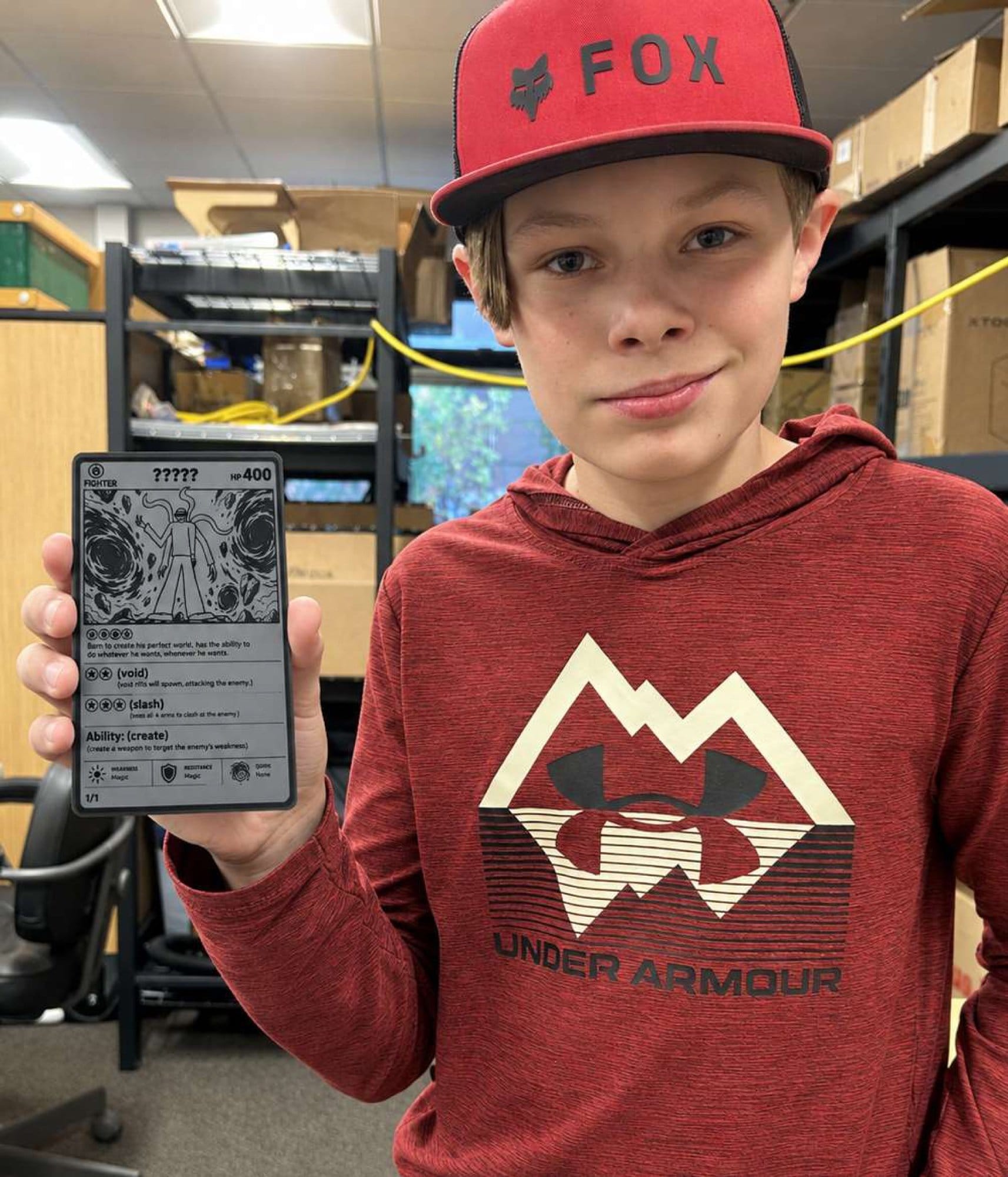 A student holding up a laser-cut, AI-designed metal trading card