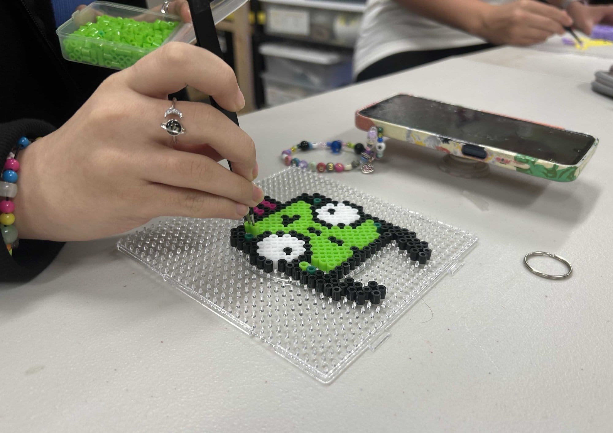 A student arranging fuse beads into pixel art